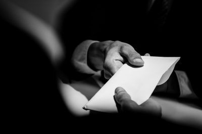 B&W hand with envelope – GettyImages-1005124908