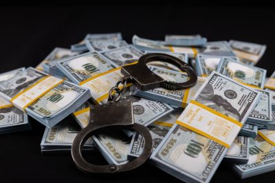 Handcuffs on bills – GettyImages-2096224109