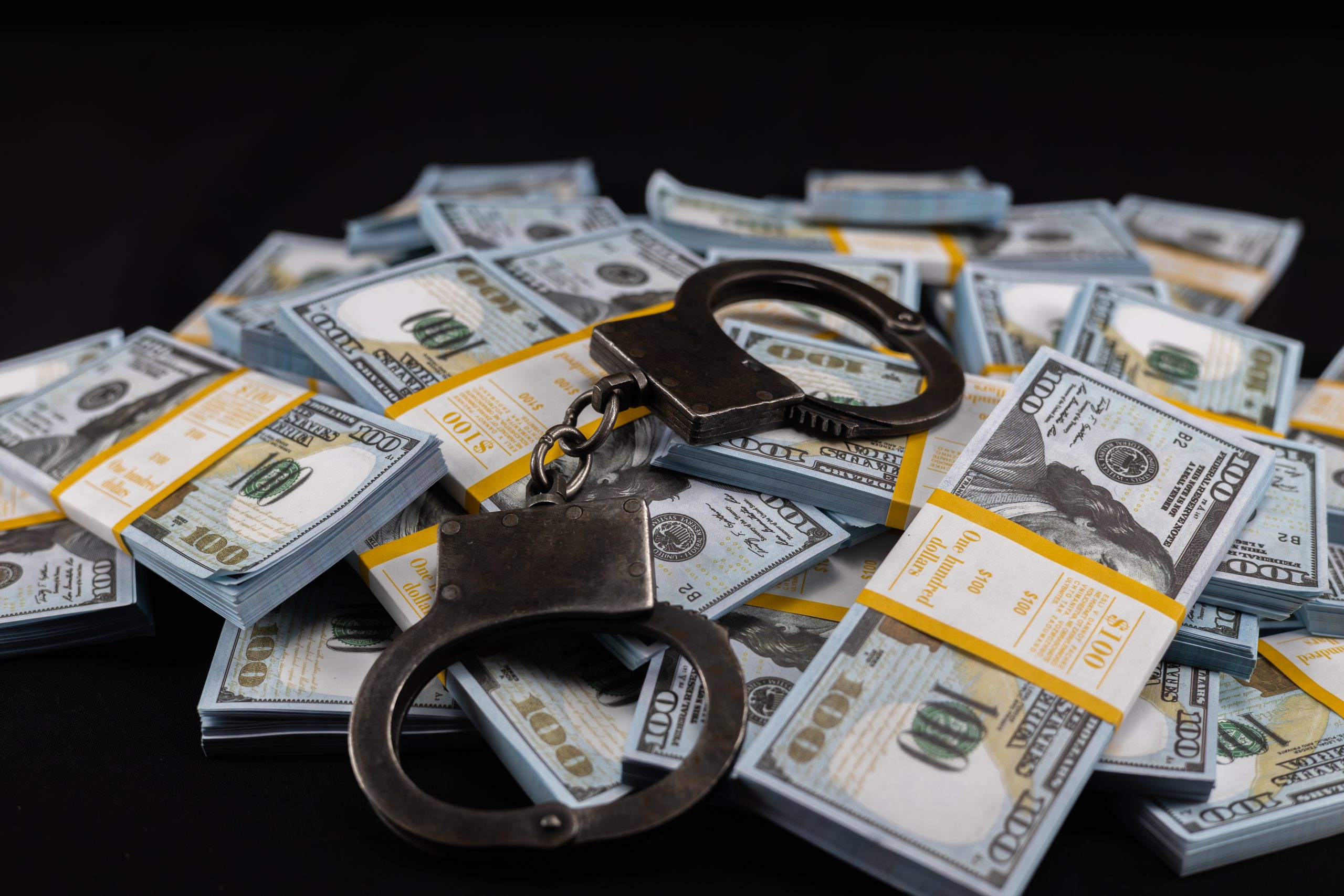 Handcuffs on bills – GettyImages-2096224109